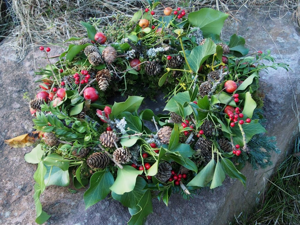 Ein Naturkranz mit Zapfen, Efeublättern, Moos und Beeren